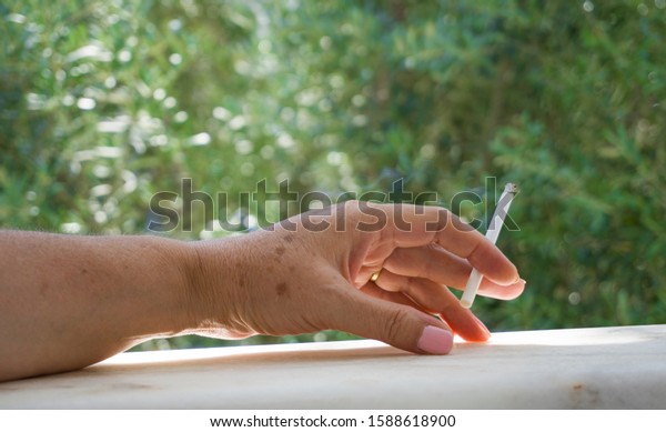 Old Woman Hand Smoking On Balcony Photo 1588618900