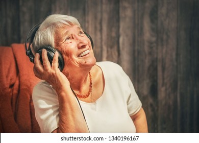 old woman in headphones listening to music