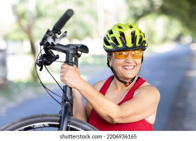  Old Woman In Helmet Carrying Mountain Bike