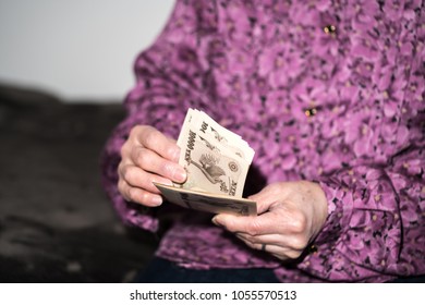 
Old Woman Holding Money