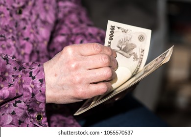 
Old Woman Holding Money