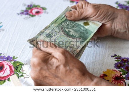 An old woman holds 100 Polish zloty banknotes in her hands, Polish money, Concept, Pension, allowance, help for the elderly