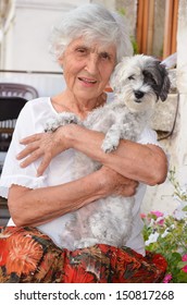 Old Woman Hugging Her Dog Smiling At The Camera