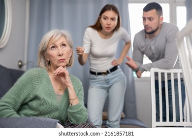 Old Woman Ignoring Her Daughter And Son-in-law Standing Behind And Arguing With Her At Home.