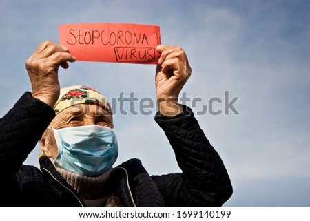 Old woman with the inscription stop coronavirus. Stop coronavirus infection. The fight against coronavirus. Coronavirus pandemic in the world. Quarantine measures.