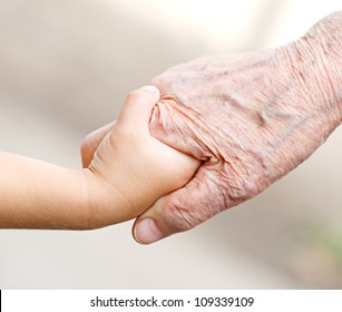 An old woman and a kid holding hands together