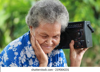 Old Woman Listening To Music With A Vintage Radio, Outdoor