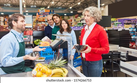 Old Woman Is Looking For Money To Pay In Wallet At Checkout From The Supermarket