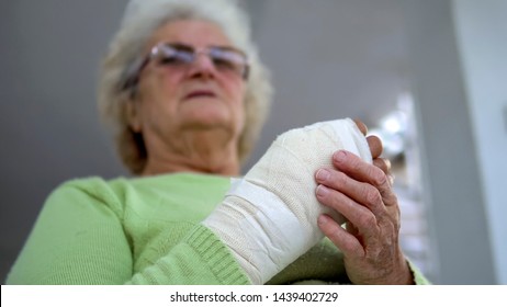 Old Woman Massage Her Injured Broken Hand Sitting, Cinematic Dof