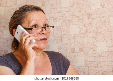 Old woman with mobile phone talking with somebody