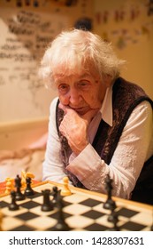 An Old Woman Is Playing Chess.