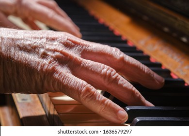 Old Woman Playing The Old Piano. Selective Focus. Silhouette Of Old Fingers On The Piano Keyboard. 