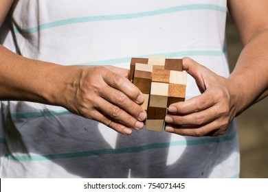 Old woman playing a wooden puzzle for train the brain
