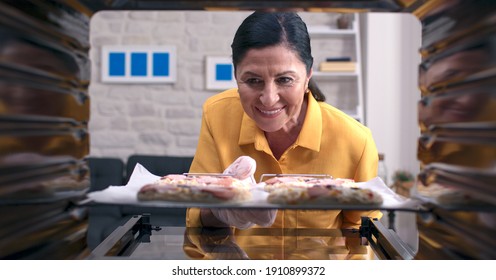 The Old Woman Is Putting Delicious Little Pizzas From The Oven. Shooting From Inside The Oven.