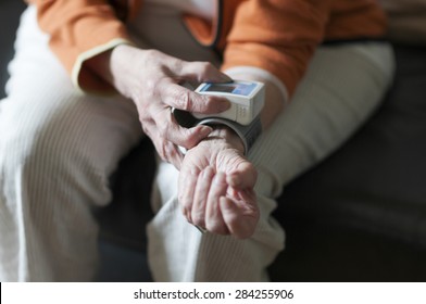 Old Woman Reading Her Blood Pressure Meter From The Arm.