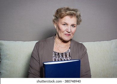 old woman reads a folder with documents