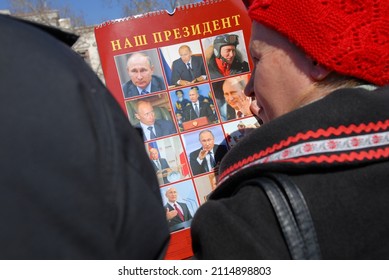 Old Woman In Red Hat Holding Vladimir Putin Portrait During Support Meeting Rally In Ukraine, Sevastopol, Crimea 29 Jan 2022