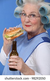 Old Woman In Rollers With A Burger And A Beer