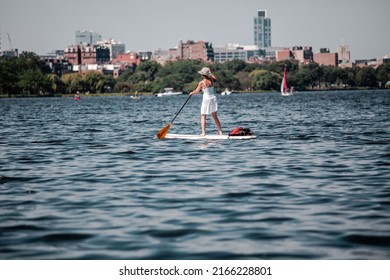 Old woman sailing on the Charles river on sunny day  with happy on Boston city background.