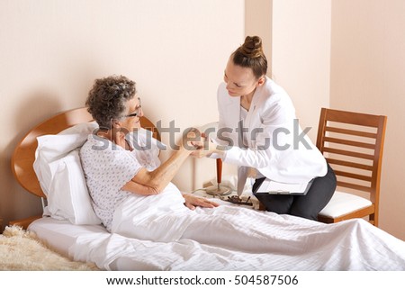 Similar – Caregiver auscultating senior woman