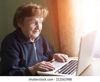 Old Woman Sing Laptop Computer At Home.