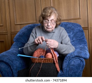 The Old Woman Sits In An Armchair And Knits