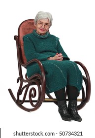 Old Woman Sitting On A Wooden Rocking Chair Isolated Against A White Background.