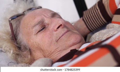 Old Woman Smiling And Talking During The Day Relaxing On Porch Swing Bed