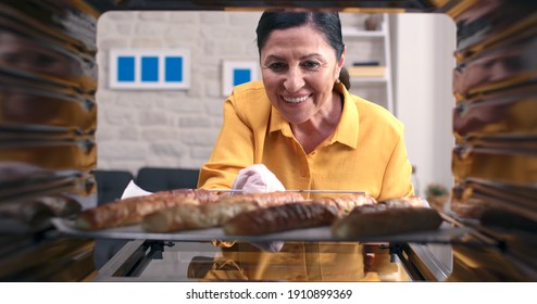 The Old Woman Takes Out Delicious Pies From The Oven. Fire In The Oven. 