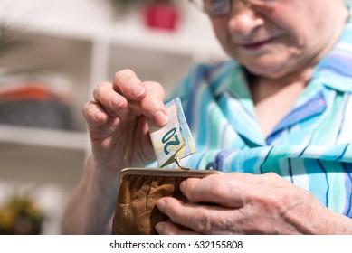 Old Woman Taking Out A Banknote From Her Wallet