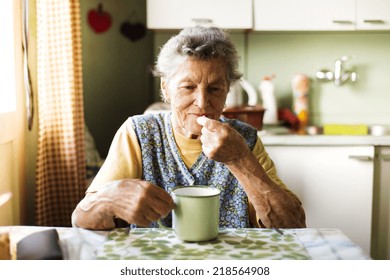 Old Woman Is Taking Pills In Her Country Style Kitchen