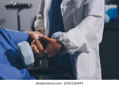 Old woman training with physiotherapist using dumbbells at home. Therapist assisting senior woman with exercises in nursing home. Elderly patient using dumbbells with outstretched arms. - Powered by Shutterstock