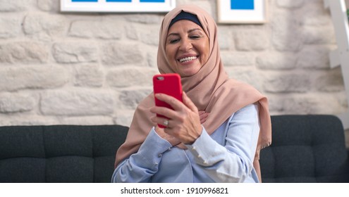 Old Woman In Turban Is Having A Video Conversation With Her Mobile Phone In Slow Motion. The Old Woman With A Turban Is Having A Video Chat With Her Loved Ones At Home.