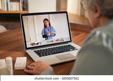 Old woman using laptop in an online consultation with her doctor during home quarantine. Senior woman at home having video call on computer with physician during covid-19 outbreak.