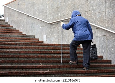 Old woman with walking cane climbing stairs outdoor. Concept for disability, limping adult, diseases of the spine - Powered by Shutterstock