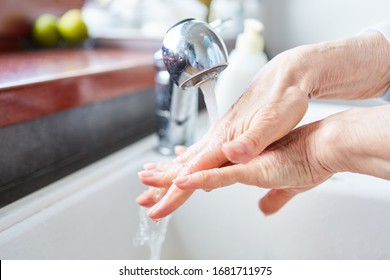 Old woman washing hands with soap as protection against infection to coronavirus epidemic - Powered by Shutterstock