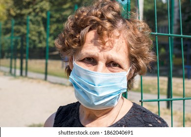 Old Woman Wearing Face Mask Outside In The Coronavirus COVID-19 Pandemic