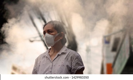 Old Woman Wearing Mask Against Air Pollution (PM2.5) In The City. PM2.5 Caused Health Problem And Respiratory System Disorder As Lung Cancer, Allergy, Asthma, Chronic Obstructive Lung Disease(COPD).