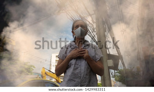 Old\
woman wearing mask for protect air pollution (PM2.5) in the city.\
PM2.5 caused health problem and respiratory system disorder as lung\
cancer, allergy, asthma, restictive lung\
disease.