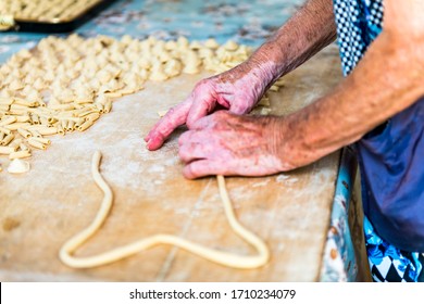 An Old Woman, While Prepare By Hands Orecchiette, Typical Italian Pasta.