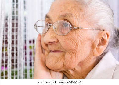 Old woman at the window, dreaming the past