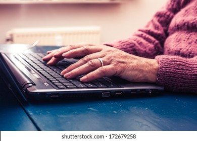 Old Woman Working On Laptop Computer At Home