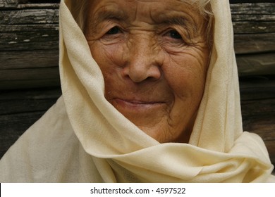 old woman wrapped in a beige scarf