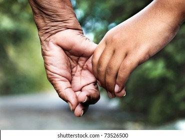 Old woman and young girl holding hands together