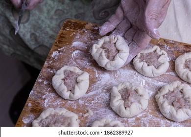 An Old Woman's Hand Holds A Made Meat Pie