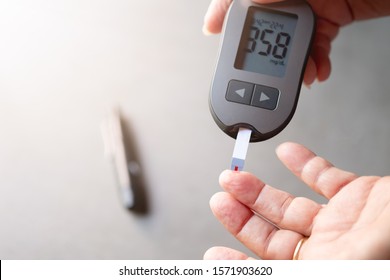 old women checks the amount of sugar in the blood. High blood sugar lever.