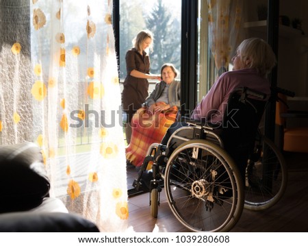 Similar – Caregiver with elderly patient in a wheelchair in front of window