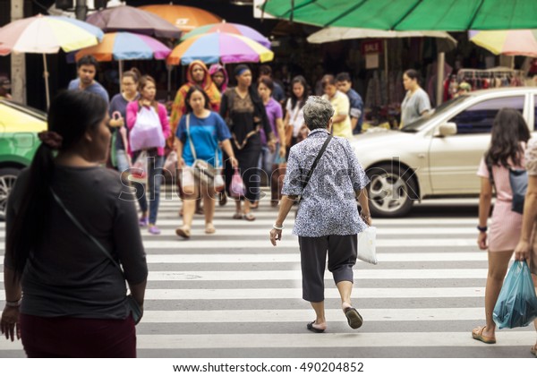 Old\
women wait for crossing city street at\
crossroad