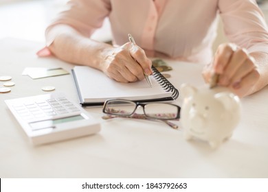 Old women's hands put money in the piggy Bank, the concept of retirement, savings. - Powered by Shutterstock