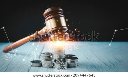 Old wood Judge hammer with stacking coins in close-up and coins stack the table wood background, Used for adjudication and Justice.